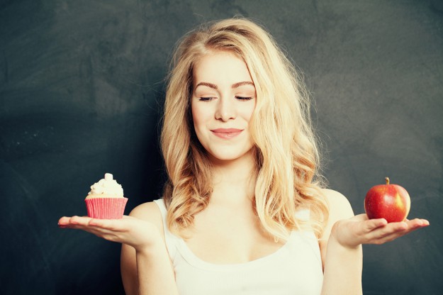 Woman with Healthy and Unhealthy Food. Difficult choice. Overwei sport, fitness, bieganie, dieta